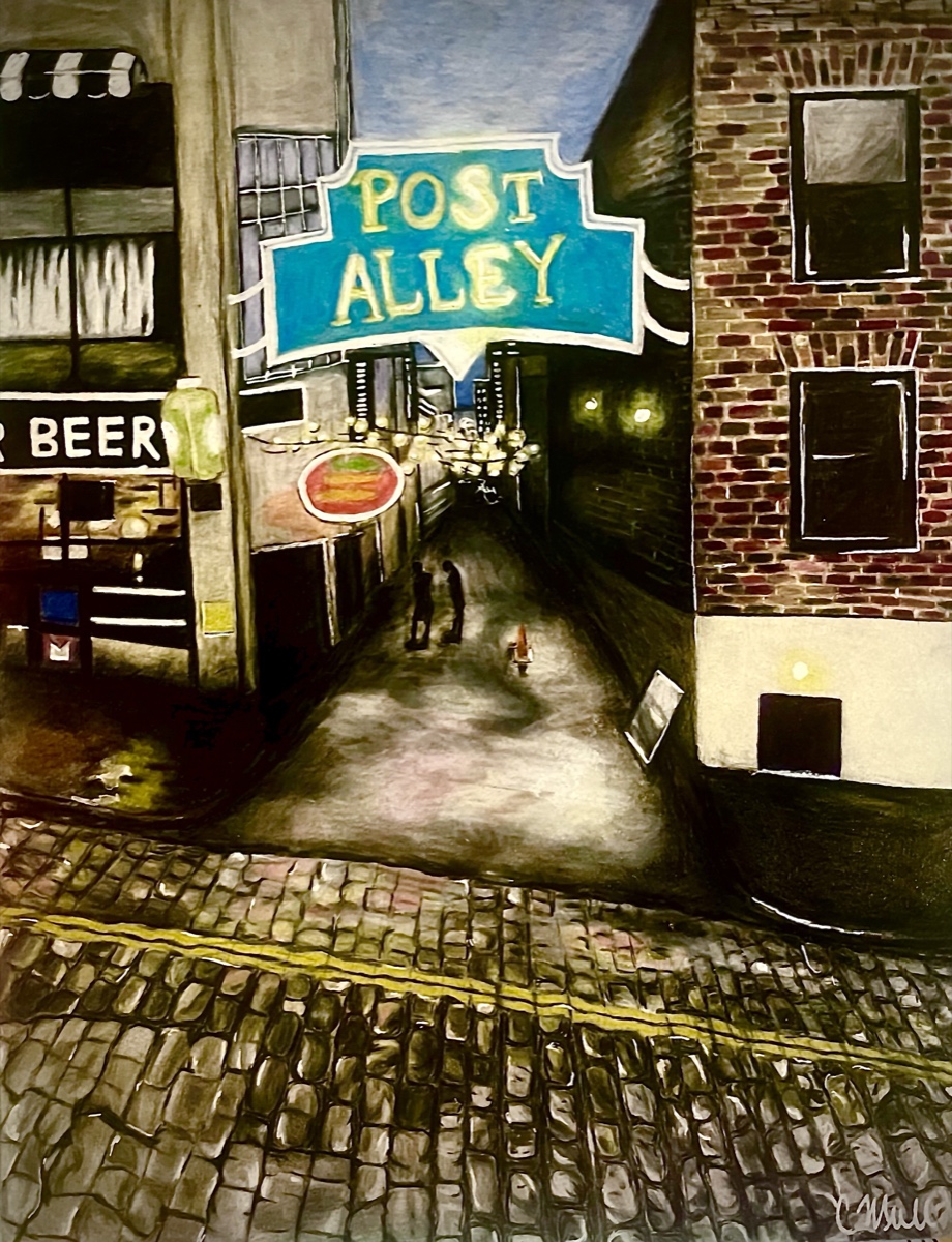 A night view down Post Alley: a lit sign spanning the alley, neon and chandelier light beyond it, brick buildings framing both sides and a broad cobblestone foreground.